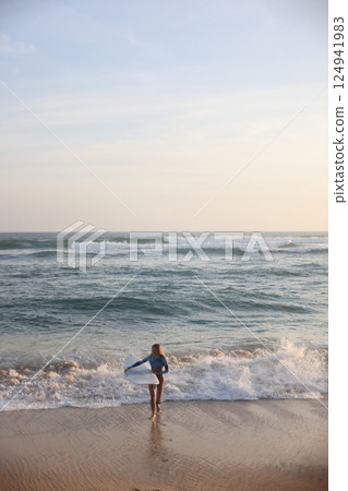 Enjoy thrilling surfing adventures as the sun sets beautifully over the serene beach Enjoy thrilling surfing adventures as the sun sets beautifully over the serene beach 124941983