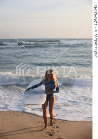 Enjoy thrilling surfing adventures as the sun sets beautifully over the serene beach 124942045