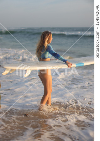 Enjoying Surfing at Sunset A Stylish, Skillful Wave Rider on the Beautiful Beach 124942046