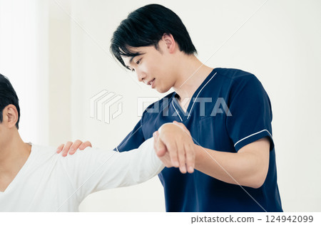 A male chiropractor performing a treatment A male chiropractor performing a treatment 124942099