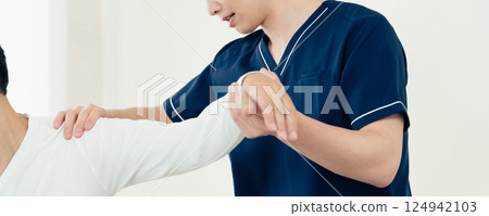 A male chiropractor performing a treatment 124942103