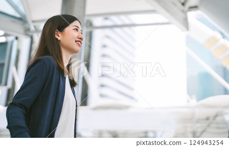 Portrait of successful business asian woman standing looking forward at outdoors in city 124943254