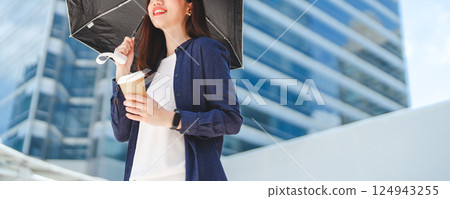 Business asian woman holding UV protection umbrella on sunny day city building background 124943255