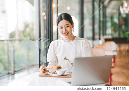 Asian woman healthy eating breakfast sandwich food diet meal at indoor cafe Asian woman healthy eating breakfast sandwich food diet meal at indoor cafe 124943263