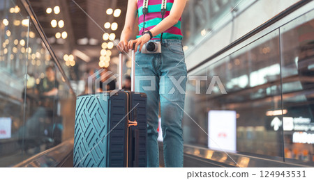 Passenger woman to transit with travel luggage and camera at international airport journey 124943531