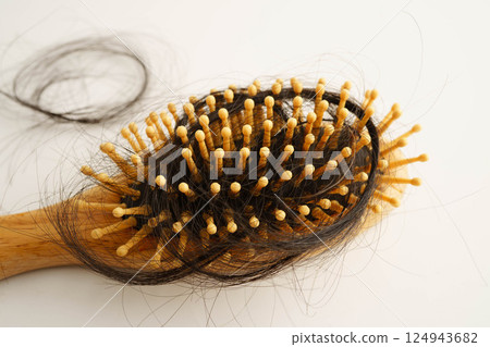 Asian woman have problem with long hair loss attach to comb brush. Asian woman have problem with long hair loss attach to comb brush. 124943682