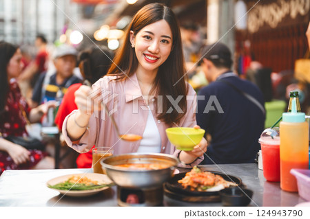 Traveler woman enjoy eating street food spicy menu travel at chinatown Yaowarat, Bangkok, Thailand 124943790