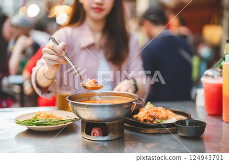 Traveler woman enjoy eating street food spicy menu travel at chinatown Yaowarat, Bangkok, Thailand 124943791