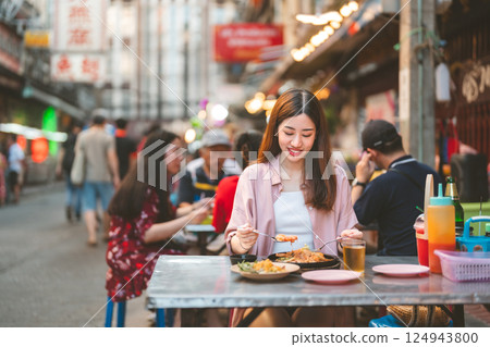 Adult travel woman enjoy eating street food spicy menu travel at chinatown Yaowarat Bangkok Thailand Adult travel woman enjoy eating street food spicy menu travel at chinatown Yaowarat Bangkok Thailand 124943800