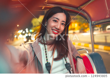Adult asian woman solo travel enjoy night trip selfie on tuk tuk local taxi Bangkok city Adult asian woman solo travel enjoy night trip selfie on tuk tuk local taxi Bangkok city 124943805