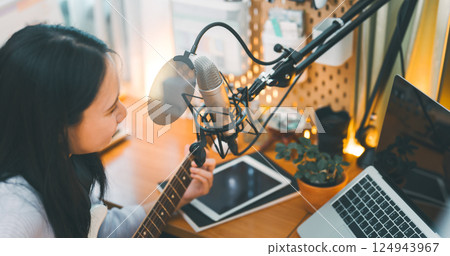 Asian woman composer playing guitar single song with microphone at home studio 124943967