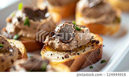 Truffle Pate de Foie Gras: Foie gras with black truffles, served on truffle crostini with truffle butter 124944916