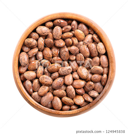 Pinto beans in a wooden bowl. Dried variety of common beans, Phaseolus vulgaris. A type of bean that are tan with reddish-brown specks. Most popular bean in Northern Mexico and Southwestern USA. Photo 124945838