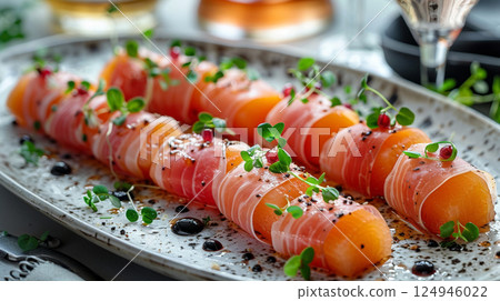 Prosciutto-wrapped melon slices elegantly arranged on a sleek white plate, garnished with microgreens and a balsamic reduction drizzle. Prosciutto-wrapped melon slices elegantly arranged on a sleek white plate, garnished with microgreens and a balsamic reduction drizzle. 124946022