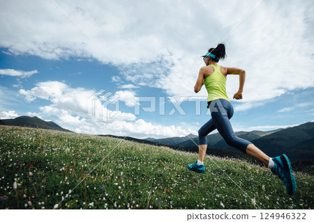 Fitness woman runner running at flowering grassland mountain top Fitness woman runner running at flowering grassland mountain top 124946322
