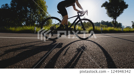 Woman cycling on summer park trail 124946342