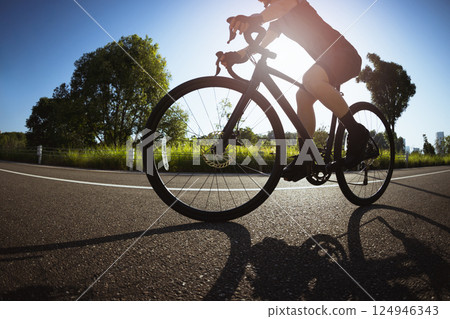 Woman cycling on summer park trail 124946343