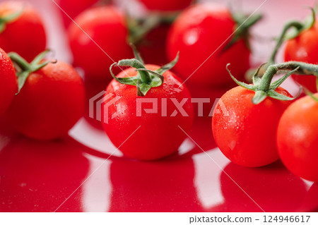 Fresh red cherry tomato on red background. Fresh red cherry tomato on red background. 124946617