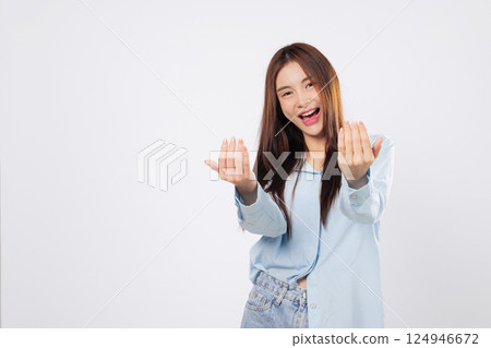 Woman uses hand gesture to beckon come here, while another woman stands with palm extended in a welcoming pose, cheerful expressions isolated in white studio background. Woman uses hand gesture to beckon come here, while another woman stands with palm extended in a welcoming pose, cheerful expressions isolated in white studio background. 124946672