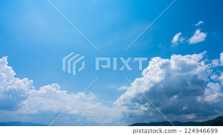 Cumulonimbus clouds over a summer blue sky and mountain scenery Cumulonimbus clouds over a summer blue sky and mountain scenery 124946699
