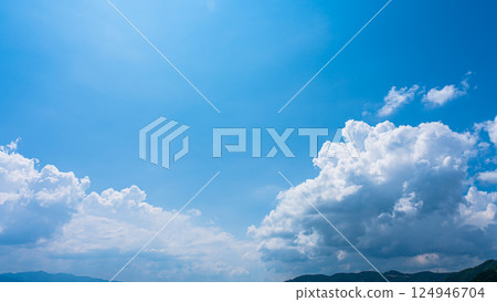 Cumulonimbus clouds over a summer blue sky and mountain scenery Cumulonimbus clouds over a summer blue sky and mountain scenery 124946704