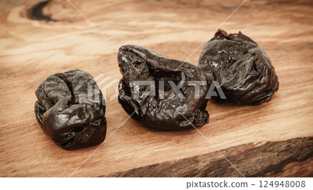 dried plums prunes on wooden table 124948008