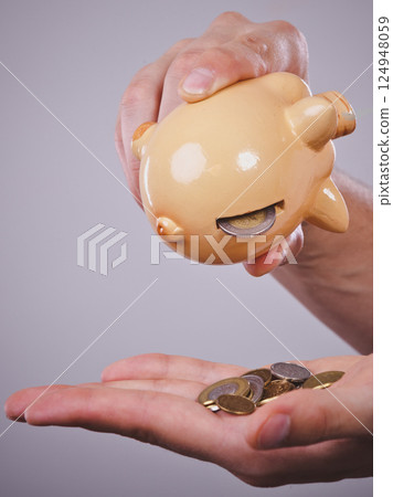 Male hands with coins and piggybank Male hands with coins and piggybank 124948059