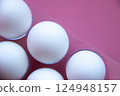 Minimalist composition White Eggs arranged on Vibrant Pink background, emphasizes Clean Lines and contrasts, culinary art, foodrelated concepts Diet Proteins Breakfast articles Easter themes 124948157