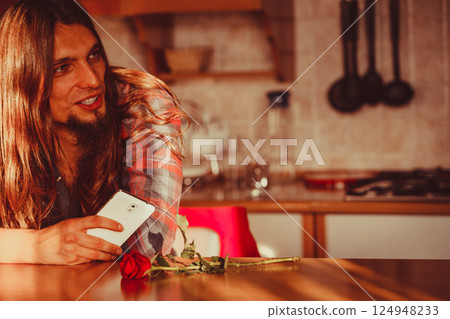 Worried man with rose and mobile phone. Worried man with rose and mobile phone. 124948233