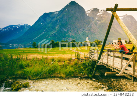 Tourist relaxing on bridge in village Oppstryn Norway 124948238