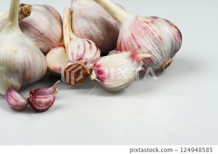 A bag of fresh garlic heads. Purple Garlic. Suitable for cooking, health, gastronomy, and nutritional topics. A bag of fresh garlic heads. Purple Garlic. Suitable for cooking, health, gastronomy, and nutritional topics. 124948585