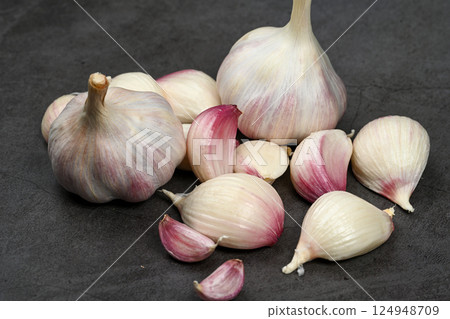 A bag of fresh garlic heads. Purple garlic. Suitable for hot drinks, health, gastronomy, nutritional topics. A bag of fresh garlic heads. Purple garlic. Suitable for hot drinks, health, gastronomy, nutritional topics. 124948709