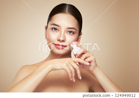 Young woman shows off a bottle with a foam dispenser for washing Young woman shows off a bottle with a foam dispenser for washing 124949012