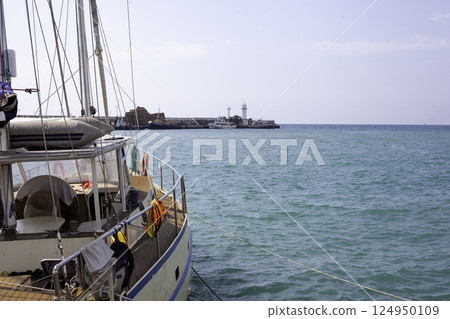 Boat yacht on the pier. Sea pier and lighthouse Yalta Boat yacht on the pier. Sea pier and lighthouse Yalta 124950109