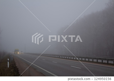 Fog on the road. Poor visibility on the highway. Cars on the motorway. 124950156