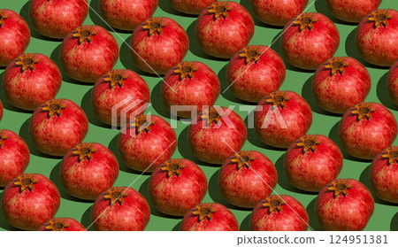 Pomegranate pattern. Red pomegranates on a green background. Fruit food. Pomegranate pattern. Red pomegranates on a green background. Fruit food. 124951381