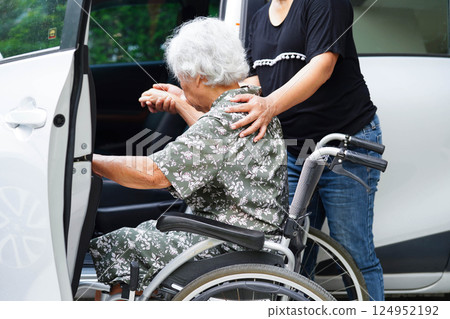 Caregiver help Asian elderly woman disability patient get in her car. Caregiver help Asian elderly woman disability patient get in her car. 124952192