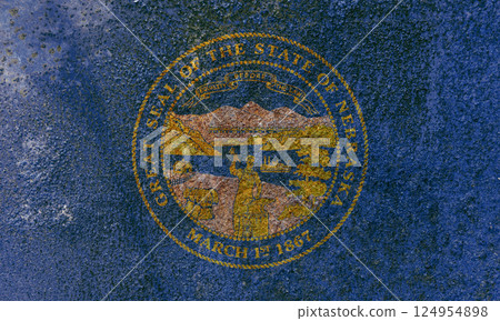 Nebraska State Flag. Dirty Nebraska state flag on rusty metal surface. 124954898
