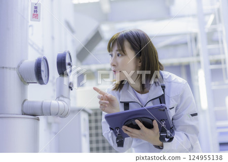 A young female worker carrying out inspection work on the roof of a building. Photo courtesy of Tokyo Electronics College, Denpa Gakuen Corporation. 124955138