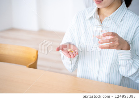 A young woman who takes medicine 124955393