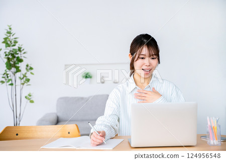 A woman looking at a computer 124956548