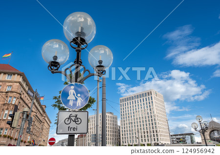 Nuremberg, Germany, August 1, 2023. Street view in the more modern part of the old town. Viewpoint from below with a street lamp in the foreground and the city in the background. Beautiful summer day. Nuremberg, Germany, August 1, 2023. Street view in the more modern part of the old town. Viewpoint from below with a street lamp in the foreground and the city in the background. Beautiful summer day. 124956942