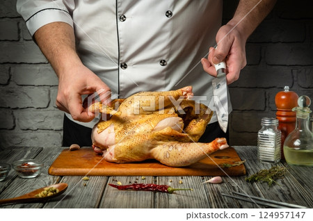 A skilled cook readies a whole chicken for roasting, meticulously seasoning it with herbs and spices. The cozy kitchen ambiance enhances the culinary experience, filled with rich aromas A skilled cook readies a whole chicken for roasting, meticulously seasoning it with herbs and spices. The cozy kitchen ambiance enhances the culinary experience, filled with rich aromas 124957147