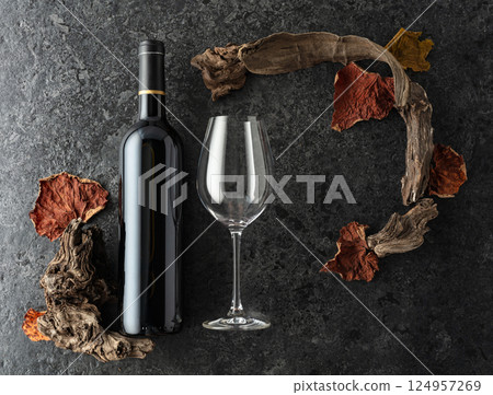 Bottle of red wine on a black stone background. 124957269