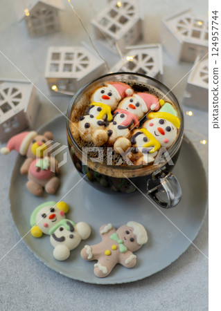 Cup of coffee with marshmallows. Marshmallow snowman in a Santa Claus hat. Winter drink. Christmas sweet food. Top view 124957744