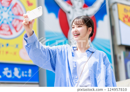 A young woman taking a selfie while sightseeing in Osaka 124957810