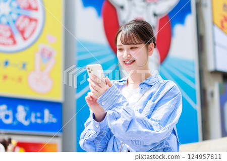 A young woman taking a selfie while sightseeing in Osaka 124957811