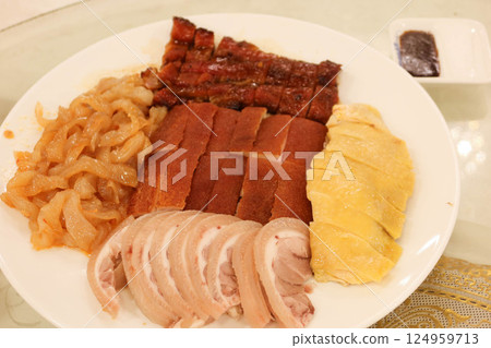 A cantonese meat platter with slices of crispy-skinned roasted duck, chicken, Suckling pig, pork trotter and jellyfish on a white plate. 124959713