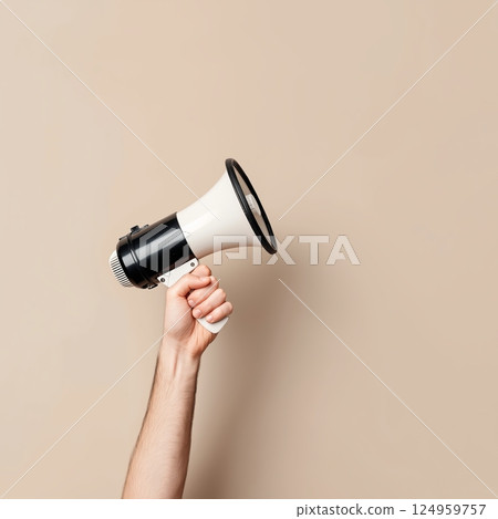 A hand holding a megaphone, symbolizing the call for awareness and social change. 124959757