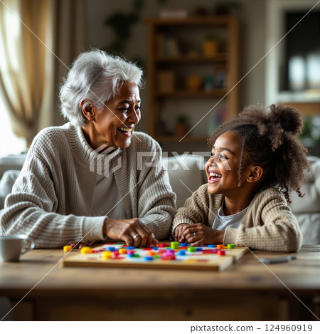 A grandmother and granddaughter play a board game, 124960919